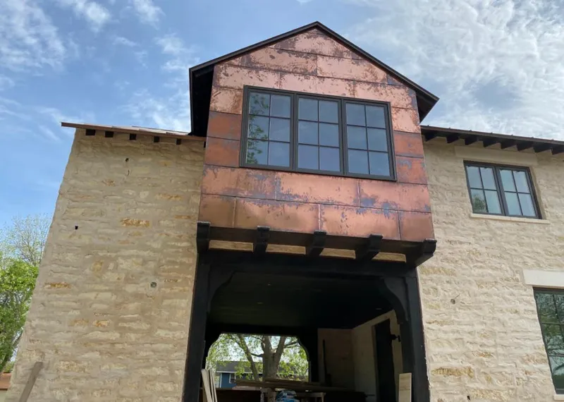 Copper metal panel facade on a stone building for Skylight Installation in Archdale